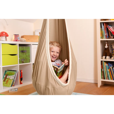 Child happily reading a book in a hammock hanging nest