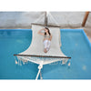 Woman in hammock hanging above swimming pool