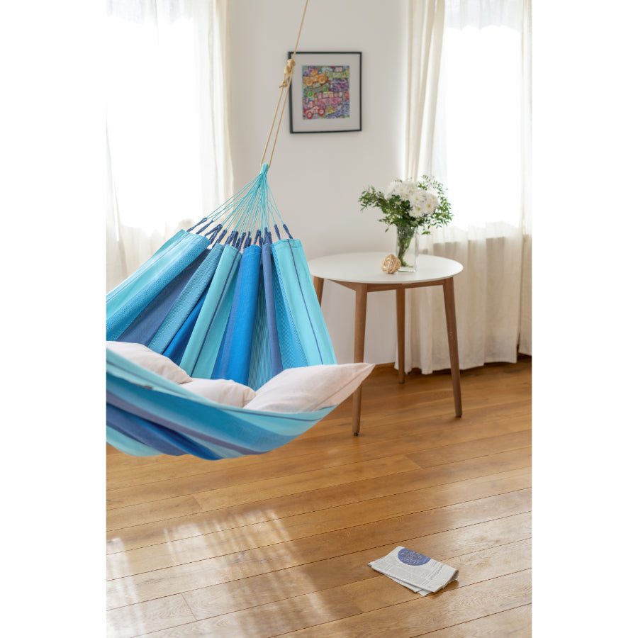 Woman reading in blue cotton hammock