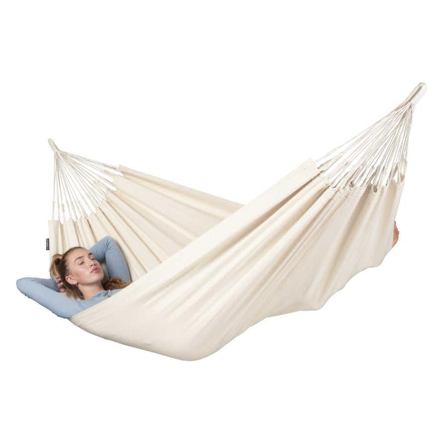 Person relaxing in a natural white hammock on a white background
