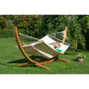 Curved wooden hammock stand with white spreader bar hammock in garden