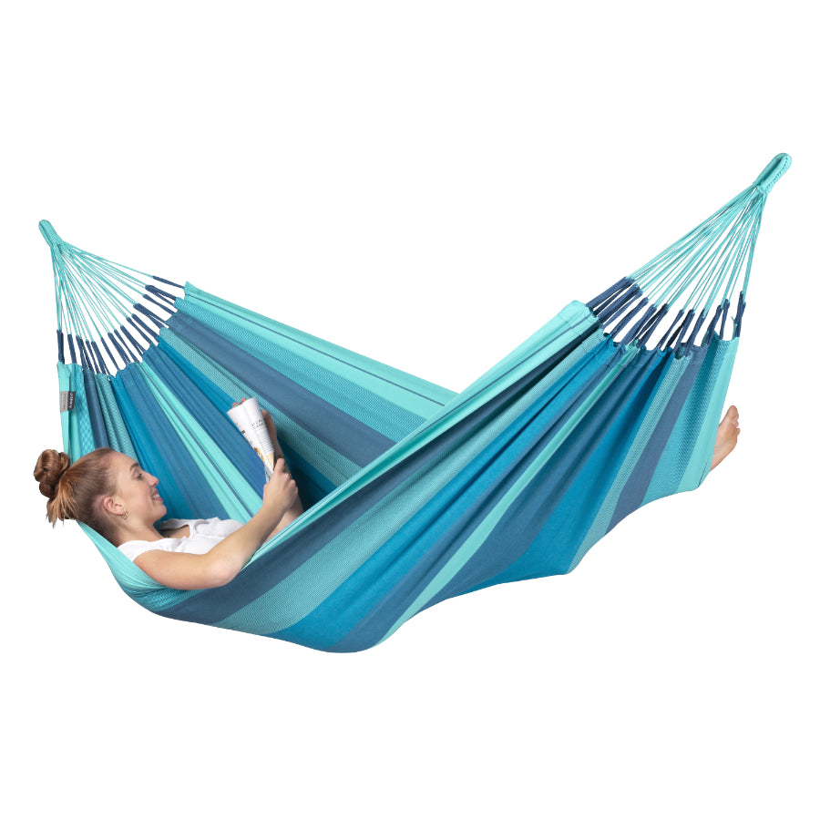Woman reading in blue cotton hammock