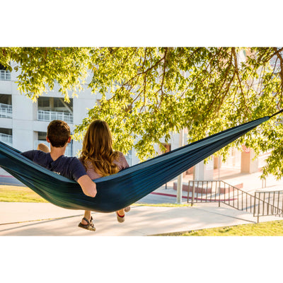 Two people in outdoor hammock in park