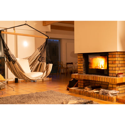 Indoor hammock chair in black and white hanging by fireplace