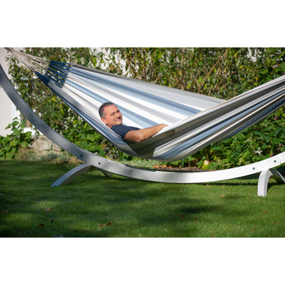 Blue and white hammock on stand in garden