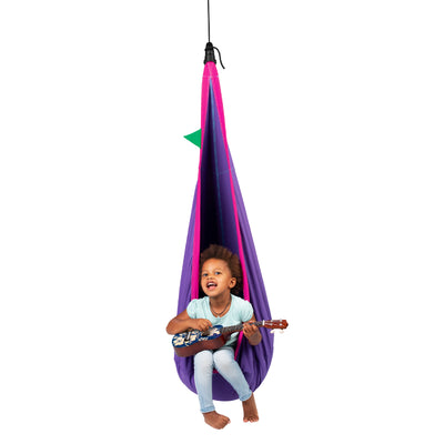 Young child playing guitar in hanging pod chair