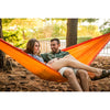 Couple relaxing outdoors in travel hammock