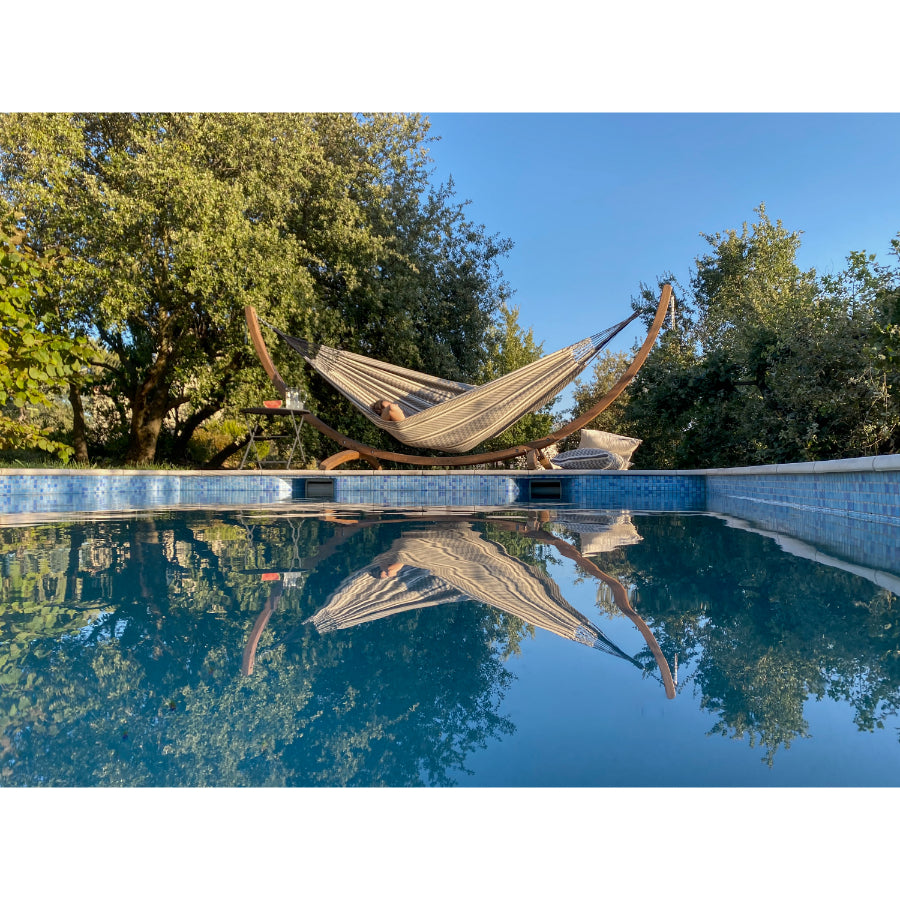Double cotton hammock on frame beside swimming pool