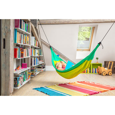 Children reading book together in hammock