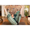 man relaxing in hammock inside with a cup of coffee