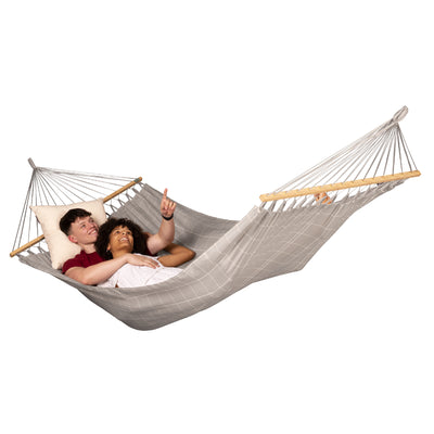 Couple relaxing in spreader bar hammock