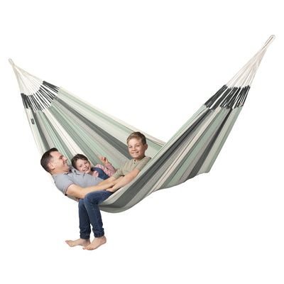 Family relaxing together in large green and white hammock