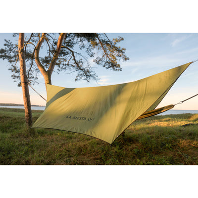 Hammock cover protecting hammock from sun or rain outdoors between trees