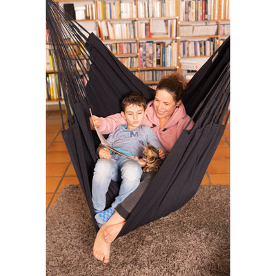 Mother and son reading book together in black chair hammock