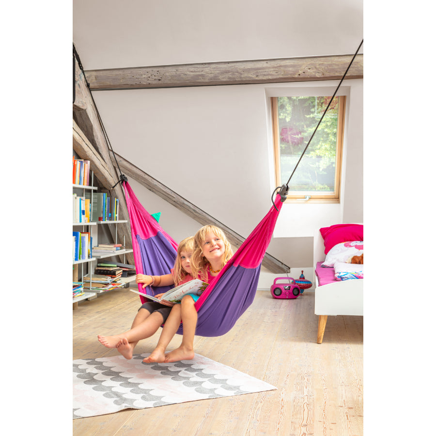 Two children reading a book in a kids hammock