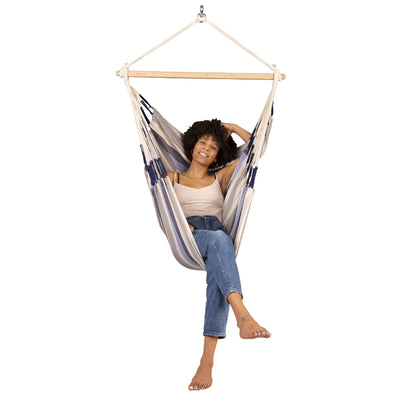 Woman relaxing in blue and white hammock chair