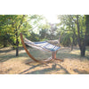 Arc wooden stand and spreader bar hammock in field