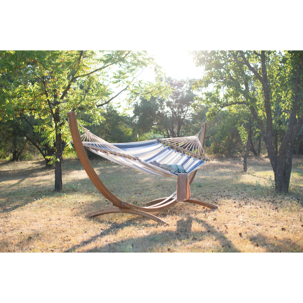 Arc wooden stand and spreader bar hammock in field